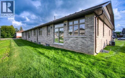 Brick exterior with multiple windows and a well-maintained lawn - 48 Main Street E, Innerkip, ON - Outdoor