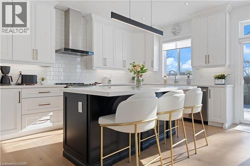 Dual tone kitchen with a kitchen breakfast bar, a kitchen island, light wood finished floors, dual tone cabinetry, and recessed lighting - 66 Cesar Place, Ancaster, ON - Indoor