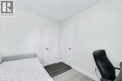Bright room featuring two white panel doors with brushed nickel hardware, wood-finish flooring, and crisp white baseboards - 
