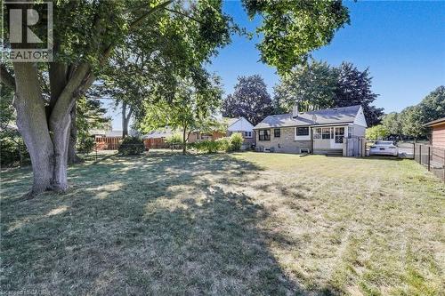 Expansive rear yard featuring mature trees, a low-maintenance lawn, and a light-brick exterior - 18 Tweedsmuir Avenue, London, ON - Outdoor