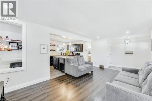 Open-concept living area featuring wood-finish flooring, recessed lighting, and a built-in shelving unit - 18 Tweedsmuir Avenue, London, ON - Indoor Photo Showing Living Room