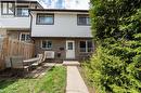 Two-story residential exterior featuring brick and siding construction, brown trim windows, a white entry door, and a concrete pathway leading to the entrance - 391 Pioneer Drive Unit# 4, Kitchener, ON  - Outdoor 