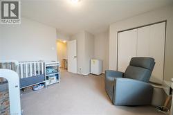 Carpeted room with neutral wall tones and a built-in closet featuring white bi-fold doors - 
