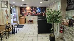 Spacious commercial interior featuring clean tile flooring and light-toned wall paneling - 