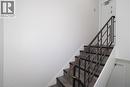 Staircase featuring wood-finish treads, white risers, and a metal handrail with black balusters - 24 Austin Drive Unit# 3, Waterloo, ON  - Indoor Photo Showing Other Room 