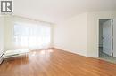 Spacious room featuring wood-finish flooring, a large window with sheer white curtains, and neutral wall paint - 24 Austin Drive Unit# 3, Waterloo, ON  - Indoor Photo Showing Other Room 