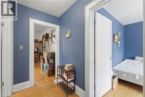 Hallway with wood-finish flooring, blue painted walls, and white trim - 509 Aberdeen Avenue, Hamilton, ON - Indoor