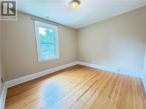 Room featuring wood flooring, neutral tone walls, a white trim window, and overhead lighting - 509 Aberdeen Avenue, Hamilton, ON - Indoor Photo Showing Other Room