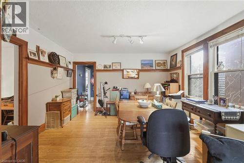Spacious room featuring wood-finish flooring, white walls with a chair rail, natural wood trim, and multiple windows providing natural light - 509 Aberdeen Avenue, Hamilton, ON - Indoor