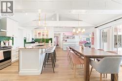 Open-concept kitchen and dining area with wood-finish flooring - 
