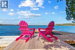 Expansive wood-finish dock extending over a body of water, featuring visible shoreline - 