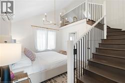 Dark wood-finish staircase with black metal balusters and white handrail - 