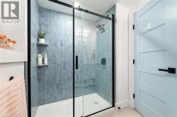 Glass-enclosed shower featuring subway tile walls, built-in shelving, and a rain showerhead - 