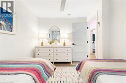 Bright bedroom with light wood-finish flooring and a contemporary five-panel interior door - 