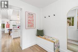 Entryway featuring wood-finish flooring, white walls, and a built-in storage bench with a wood-finish top - 