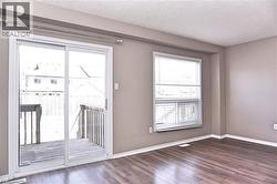 Interior space featuring wood-finish flooring, neutral wall tones, and white baseboards - 