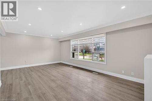 Spacious room featuring wood-finish flooring, recessed lighting, and crown molding - 53 Nicklin Crescent, Guelph, ON - Indoor