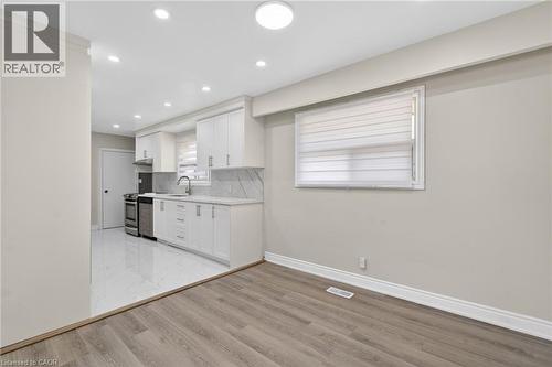Kitchen featuring white cabinetry, stainless steel appliances, and a tiled backsplash - 53 Nicklin Crescent, Guelph, ON - Indoor Photo Showing Kitchen