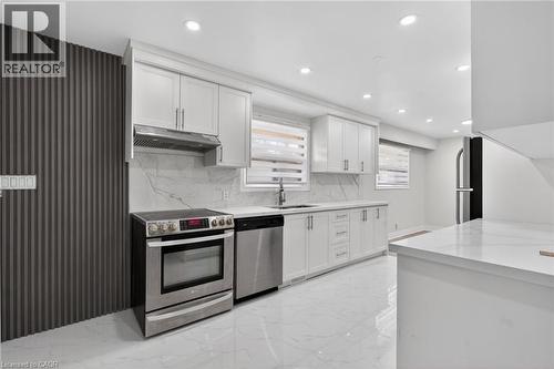 Modern kitchen featuring white cabinetry, stainless steel appliances, a marble-patterned backsplash, white quartz countertops, and recessed lighting - 53 Nicklin Crescent, Guelph, ON - Indoor Photo Showing Kitchen With Stainless Steel Kitchen