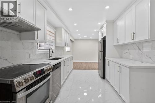 Modern kitchen featuring white shaker cabinetry, stainless steel appliances, white countertops, and a white marble-patterned backsplash - 53 Nicklin Crescent, Guelph, ON - Indoor Photo Showing Kitchen With Stainless Steel Kitchen With Double Sink With Upgraded Kitchen