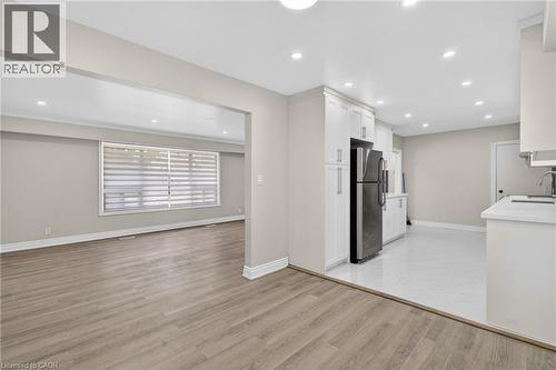 Bright open-concept living space featuring wood-finish flooring in the living area and white tile flooring in the kitchen - 53 Nicklin Crescent, Guelph, ON - Indoor