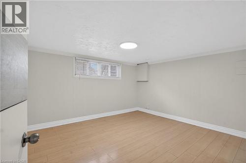 Neutral-toned walls complement wood-finish flooring in this versatile space - 53 Nicklin Crescent, Guelph, ON - Indoor Photo Showing Other Room