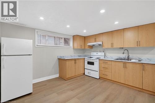 Kitchen featuring light wood-finish cabinetry, white appliances, and marble-look countertops - 53 Nicklin Crescent, Guelph, ON - Indoor Photo Showing Kitchen With Double Sink