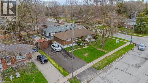 Brown brick exterior featuring a brown shingle roof, established front lawn, paved driveway, and detached storage sheds - 53 Nicklin Crescent, Guelph, ON - Outdoor