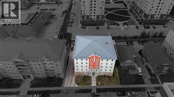 Multi-story building featuring a light blue hip roof, a prominent red central facade, and multiple windows - 