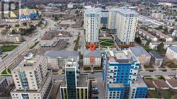 Aerial perspective showcasing a multi-story building prominently marked, surrounded by other residential and commercial structures - 