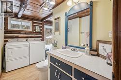 Bathroom featuring a vanity with a white tile countertop, built-in cabinetry, and an integrated sink basin - 