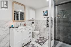 White vanity with a rectangular undermount sink, a chrome widespread faucet, and a light wood-framed mirror - 
