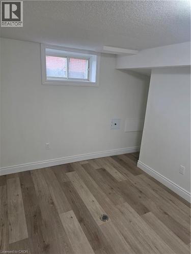Room featuring wood-finish flooring, white baseboards, and a window with white trim - 22 Montrose Avenue, Kitchener, ON - Indoor Photo Showing Other Room