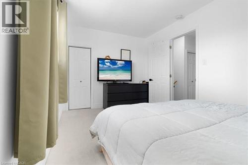 Light-colored carpeting throughout, white painted walls, and a bi-fold closet door - 133 Frederick Avenue, Hamilton, ON - Indoor Photo Showing Bedroom