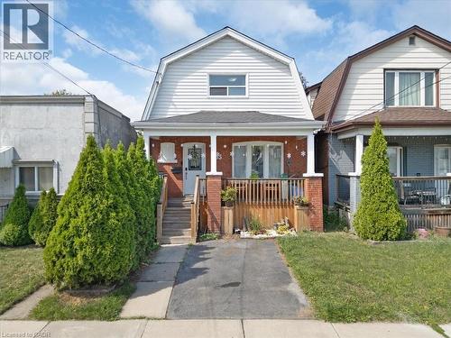 Brick and siding exterior featuring a covered front porch with white columns and wood railing - 133 Frederick Avenue, Hamilton, ON - Outdoor With Deck Patio Veranda With Facade