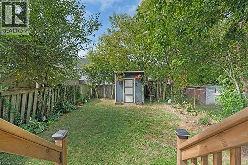Expansive backyard featuring a central lawn, mature perimeter trees, and a modern utility shed - 133 Frederick Avenue, Hamilton, ON - Outdoor