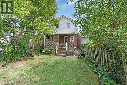 Expansive rear yard featuring a wooden deck with lattice railing, mature trees, and a grassy lawn - 133 Frederick Avenue, Hamilton, ON - Outdoor