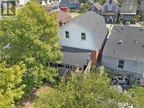 Rear exterior featuring white siding, a dark asphalt shingle roof, and a covered back deck - 133 Frederick Avenue, Hamilton, ON - Outdoor