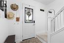 Entryway featuring a white paneled door with decorative glass insert, bright white walls, an arched built-in detail, and a carpeted staircase with white balusters - 133 Frederick Avenue, Hamilton, ON  - Indoor Photo Showing Other Room 