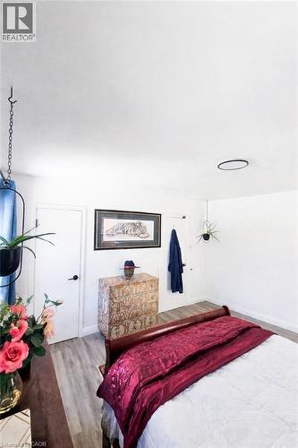 Spacious room featuring wood-finish flooring, white walls, and a contemporary flush-mount ceiling light - 34 Christopher Drive, Cambridge, ON - Indoor Photo Showing Bedroom