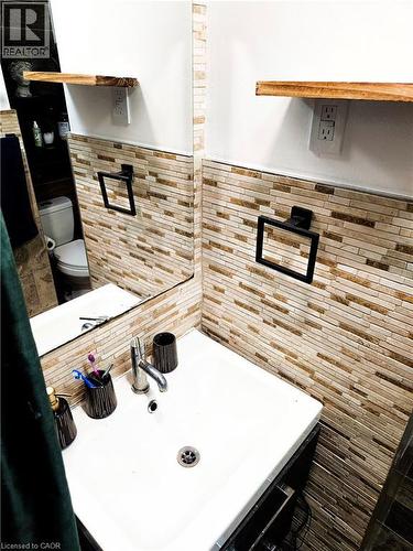 Bathroom vanity with white basin sink, polished chrome faucet, and integrated black cabinetry - 34 Christopher Drive, Cambridge, ON - Indoor