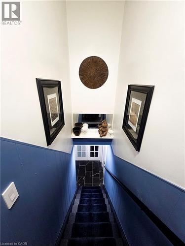 Staircase featuring dark blue carpeted treads and wainscoting - 34 Christopher Drive, Cambridge, ON - Indoor