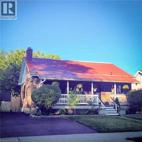 Brick exterior with a prominent red metal roof - 34 Christopher Drive, Cambridge, ON - Outdoor With Deck Patio Veranda