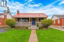 Brick exterior featuring a bright red metal roof, covered front porch, and a vibrant blue entry door - 34 Christopher Drive, Cambridge, ON  - Outdoor With Deck Patio Veranda 
