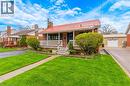 Brick exterior with a red metal roof, a front porch featuring white railings, and mature front landscaping - 34 Christopher Drive, Cambridge, ON  - Outdoor With Deck Patio Veranda With Facade 