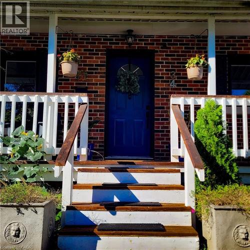 Brick facade with a contrasting blue entry door featuring an arched window - 34 Christopher Drive, Cambridge, ON - Outdoor