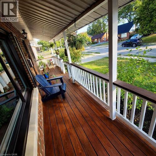 Front porch featuring rich wood-finish flooring, white railing with dark wood-finish top, white support columns, and a corrugated metal ceiling - 34 Christopher Drive, Cambridge, ON - Outdoor With Deck Patio Veranda With Exterior