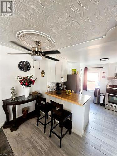 Kitchen area featuring light wood-finish flooring and a breakfast bar with a wood countertop - 34 Christopher Drive, Cambridge, ON - Indoor Photo Showing Other Room