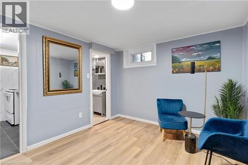 Interior room featuring wood-finish flooring, light blue paneled walls, and white trim - 34 Christopher Drive, Cambridge, ON - Indoor