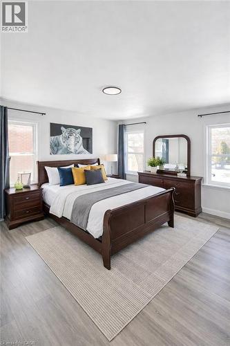 Spacious room featuring light wood-finish flooring, white walls, and a contemporary flush-mount ceiling light - 34 Christopher Drive, Cambridge, ON - Indoor Photo Showing Bedroom